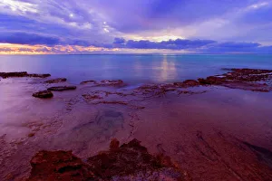 Sunset over the Reef - colourful sunset over Ningaloo Reef and the ocean. Heavy clouds darken the sky Sunset over the Reef - colourful sunset over Ningaloo Reef and the ocean. Heavy clouds darken the sky