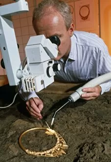 Images Dated 2nd July 2003: Archaeologist cleaning a golden Celtic necklace
