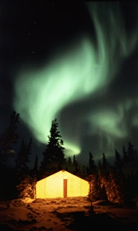 Aurora borealis over a lighted tent Print