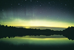 Aurora borealis display reflected upon water Aurora borealis display reflected upon water