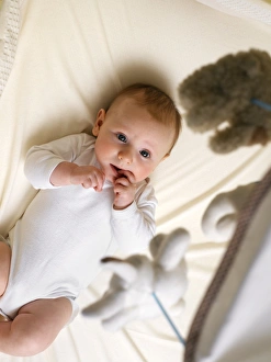 Prints of MODEL RELEASED. Baby boy in a cot watching a mobile Images Dated 2005 April: Baby in a Cot Print