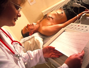 Doctor examines a male patients ECG trace Doctor examines a male patients ECG trace