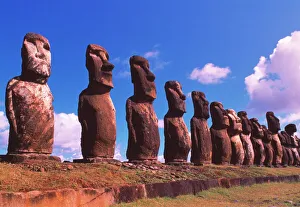 Prints of Easter Island statues. Row of megalithic moai statues on Easter Island (Rapa Nui) in the South Pacific. The statues top an ahu (burial platform) and look inland from beside the sea Megalithic Prints: Easter Island Moai Print