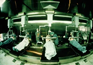 Images Dated 2003: Print of surgeons operating in a conveyer-belt theatre, 1986