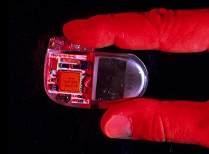 Fingers hold a heart pacemaker for implantation Fingers hold a heart pacemaker for implantation
