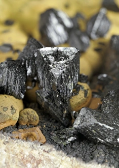 Libethenite Print: Dark green wedge-shaped crystals with pale brown duftite