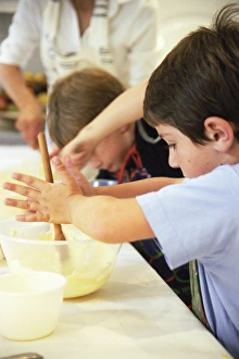 Print of a 5-year-old boy mixing cake ingredients