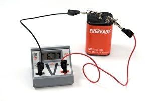 Prints of Measuring a batterys voltage. Voltmeter connected between the terminals of a battery in order to measure its voltage. The meter is showing a reading of 6.77V Images Dated 2009 July: 6.77V Battery Voltage Print