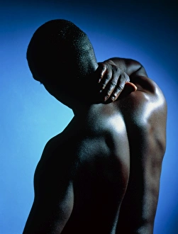 Neck/shoulder pain: black man with hand on neck Neck/shoulder pain: black man with hand on neck