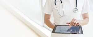 Medical Technology Images Prints: Nurse using a tablet computer F008 / 2916