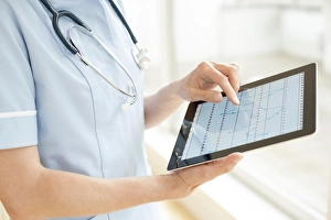 Medical Technology Images Prints: Nurse using a tablet computer F008 / 2923