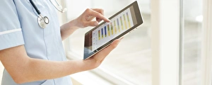 Digital Healthcare Solutions Prints: Nurse using a tablet computer F008 / 2925