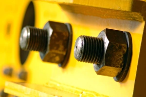 Prints of Nuts and bolts. Close-up of nuts screwed onto bolts to hold together parts of a metal structure (yellow). The circular rings between the nuts and the main body of the structure are called washers Images Dated 2008 November: Metal fasteners Print