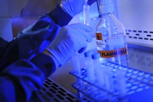 Scientist In Lab Coat Prints: Scientist decanting ethanol