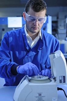 Scientist At Work Prints: Scientist loading a centrifuge