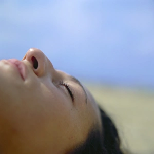 Prints of MODEL RELEASED. Face of a woman sleeping on a sandy beach Images Dated 2003 March: Sleeping Woman Print on Sandy Beach