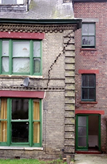Prints of Subsidence. A large crack in the outside wall of a house caused by subsidence. Subsidence is the sinking of land. It may be natural or due to the activities of man Images Dated 2004 December: Subsidence Print: A Large Crack in a House Wall