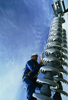 Technician servicing a power line insulator Technician servicing a power line insulator