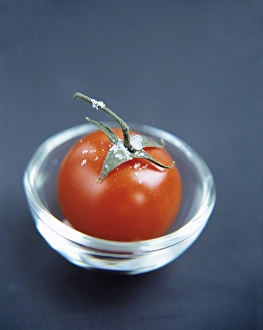 Prints of Tomato (Lycopersicon esculentum) in a glass bowl. This fruit has many uses in cooking and is a good source of vitamins A and C Images Dated 2004 August: Tomato Print in a Glass Bowl