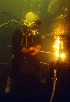 Prints of Underwater welding. Diver welding an underwater pipe. Commercial divers use welding tools to repair damaged underwater pipes, ships or oil rig platforms Images Dated 2006 December: Underwater Welding Print