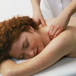Woman receives a neck and shoulder massage Woman receives a neck and shoulder massage