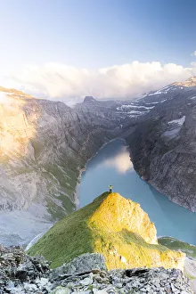 Aerial view of cheerful man with outstretched arms admiring lake Limmernsee at sunset Aerial view of cheerful man with outstretched arms admiring lake Limmernsee at sunset