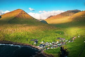 Denmark Collection: Aerial view of the coastal village of Gjogv and mountains at sunrise, Eysturoy Island
