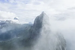 Aerial view of fog over the majestic Segla Mountain peak emerging from clouds Aerial view of fog over the majestic Segla Mountain peak emerging from clouds