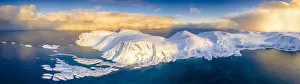 Arctic sunrise on snow capped mountains and cold sea, aerial view, Sorvaer, Soroya Island Arctic sunrise on snow capped mountains and cold sea, aerial view, Sorvaer, Soroya Island