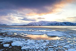 Arctic sunset on snow capped mountains and frozen sea, Tanamunningen Nature Reserve Arctic sunset on snow capped mountains and frozen sea, Tanamunningen Nature Reserve