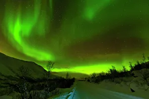 Aurora borealis (Northern Lights) seen over a snow covered road, Troms, North Norway Aurora borealis (Northern Lights) seen over a snow covered road, Troms, North Norway