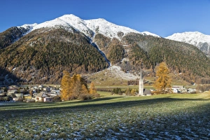 Autumn colors frame the village of Zernez surrounded by woods and snowy peaks, Engadine Autumn colors frame the village of Zernez surrounded by woods and snowy peaks, Engadine