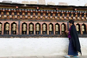 Bhutanese woman turning Buddhist prayer wheels, Trashi Chhoe Dzong, Thimphu, Bhutan, Asia Bhutanese woman turning Buddhist prayer wheels, Trashi Chhoe Dzong, Thimphu, Bhutan, Asia