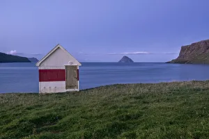 Blue hour at a small wooden house by the sea on Suduroy, Faroe Islands, Denmark, Europe Blue hour at a small wooden house by the sea on Suduroy, Faroe Islands, Denmark, Europe