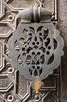 Bronze knocker on wooden engraved doors, Reales Alcazares, Seville, Andalucia Bronze knocker on wooden engraved doors, Reales Alcazares, Seville, Andalucia