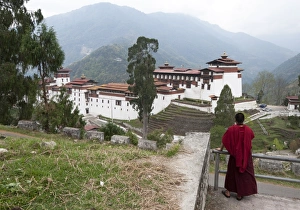 Buddhist monk looking back at Trongsa Dzong, Bhutans largest monastery fortress Buddhist monk looking back at Trongsa Dzong, Bhutans largest monastery fortress
