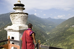 Buddhist monk looking over the Valley of the Puna Tsang River, Trongsa Dzong Buddhist monk looking over the Valley of the Puna Tsang River, Trongsa Dzong