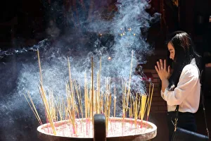 Buddhist worshipper burning incense sticks, Chua On Lang Taoist Temple, Ho Chi Minh City Buddhist worshipper burning incense sticks, Chua On Lang Taoist Temple, Ho Chi Minh City