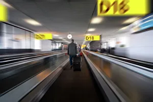 Businessman with luggage on travelator at Schiphol airport, Amsterdam, Netherlands Businessman with luggage on travelator at Schiphol airport, Amsterdam, Netherlands