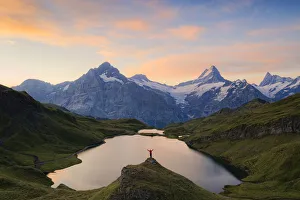 Cheerful hiker admiring Wetterhorn, Schreckhorn and Finsteraarhorn from Bachalpsee at Cheerful hiker admiring Wetterhorn, Schreckhorn and Finsteraarhorn from Bachalpsee at