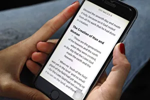 Christian woman reading a digital Bible in English on a smartphone, Vietnam, Indochina Christian woman reading a digital Bible in English on a smartphone, Vietnam, Indochina