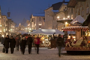 Christmas Market stalls and people at Marktstrasse at twilight, Bad Tolz spa town, Bavaria, Germany