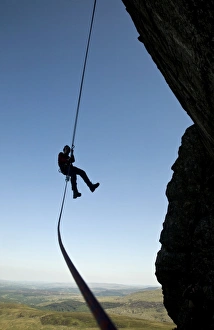 Europe Travel Photography Prints: A climber abseiling from a cliff in the Ogwen Valley, Snowdonia, North Wales