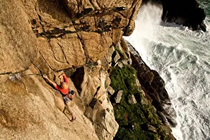 A climber on the classic extreme route Raven Wall on the cliffs at Bosigran, near St A climber on the classic extreme route Raven Wall on the cliffs at Bosigran, near St