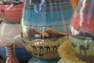 Close up of sand bottles with camels in landscapes Close up of sand bottles with camels in landscapes