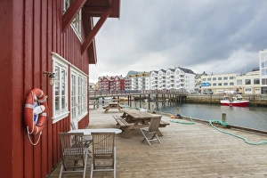Clouds frame the typical wooden houses of the fishing village surrounded by sea, Svolvaer Clouds frame the typical wooden houses of the fishing village surrounded by sea, Svolvaer