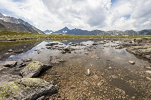 Clouds on rocky peaks reflected in the alpine Lake Schottensee, Fluela Pass, canton of Graubunden Clouds on rocky peaks reflected in the alpine Lake Schottensee, Fluela Pass, canton of Graubunden