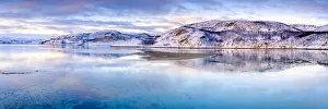 Clouds at sunset on snow capped mountains reflected in the clear water of Laksefjorden Clouds at sunset on snow capped mountains reflected in the clear water of Laksefjorden