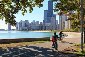 Cyclists riding along Lake Michigan shore with the Chicago skyline beyond, Chicago Cyclists riding along Lake Michigan shore with the Chicago skyline beyond, Chicago