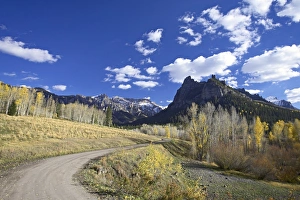 Dirt mountain road with aspens and cottonwoods in fall color Dirt mountain road with aspens and cottonwoods in fall color